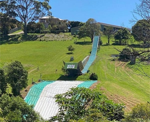 A large SunparkAirbag inflatable landing mat provides a professional training setup for snowboarder Valentino Guseli